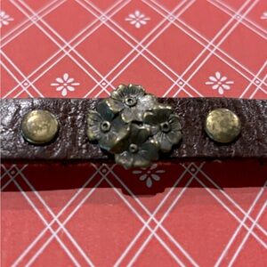 Leather cuff bracelet with brass detail.